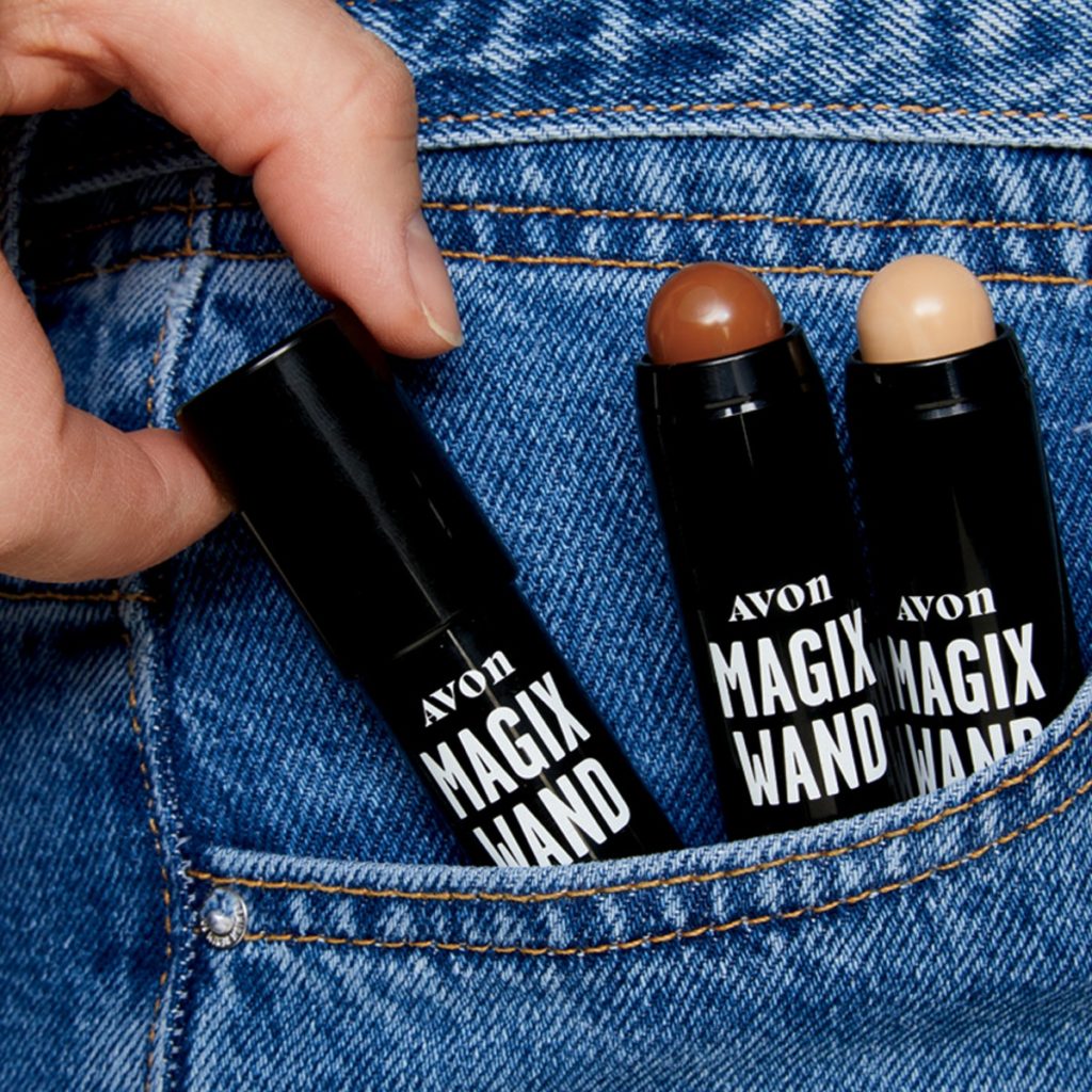 Close up of a woman's jeans pocket which is filled with 3 tubes of MagiX Wand foundation stick