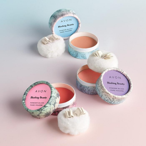 Three open containers of Blushing Beauty Powder Blush, against an ombre blue and pink background