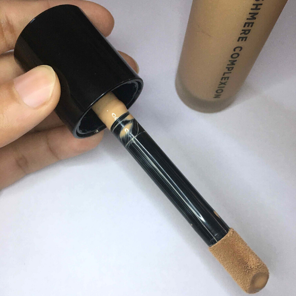 hand holding the doe foot applicator of a bottle of cashmere foundation