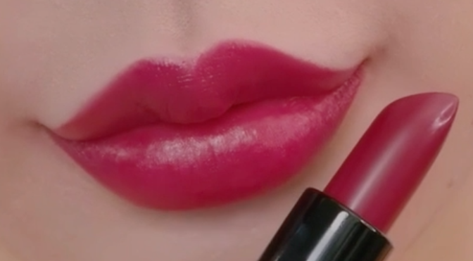 Close up of a woman's lips showing Rouge Satin Moisture Lipstick in the shade Purple Wave