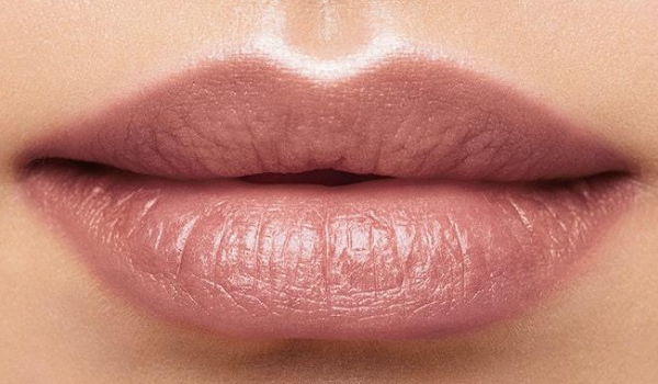 Close up of a woman's lips showing Birthday Balm Lip Crayon in the shade Surprise!