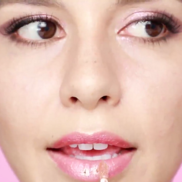 Close up of a woman's face as she applies metallic lipstick to her lips