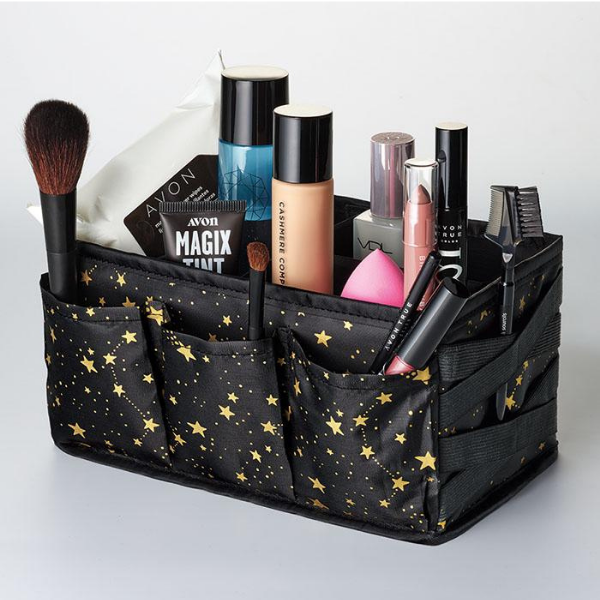 Holiday Beauty Caddy in Black and gold filled with miscellaneous makeup items, against a light grey background
