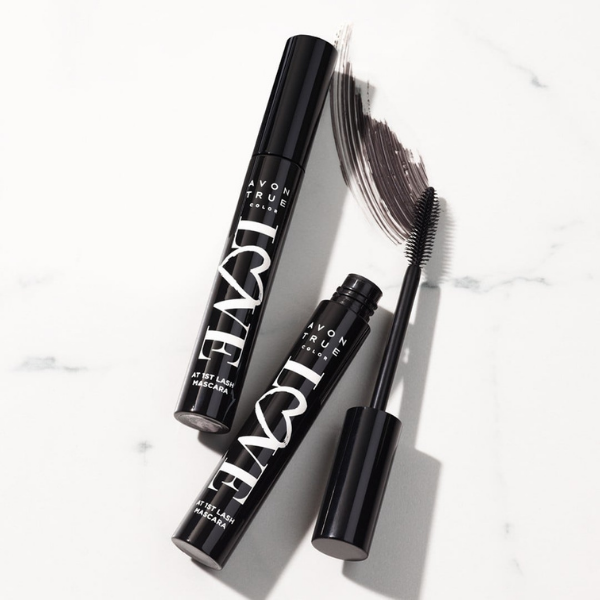 Two tubes of Love at 1st Lash mascara, an Avon vegan makeup product, against a marble background