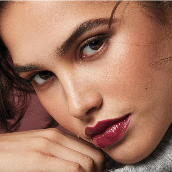 Serious looking woman wearing Cashmere Essence Lipcream in the shade Cherry Rush, as she tilts her head downwards and looks at the camera