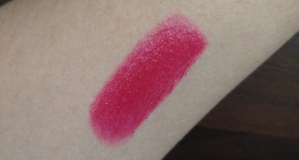 Arm swatch showing the shade Hibiscus of Glimmer Satin Lipstick