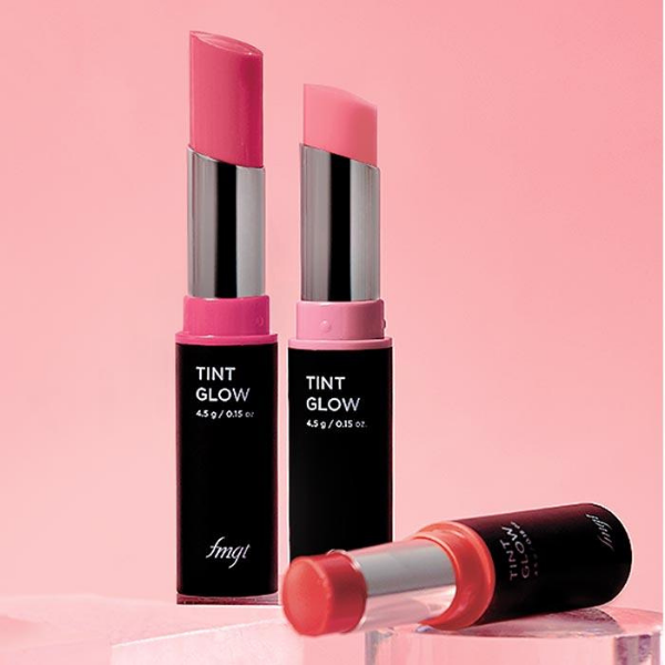 Three Open tubes of fmgt Tint Glow, against a pink background