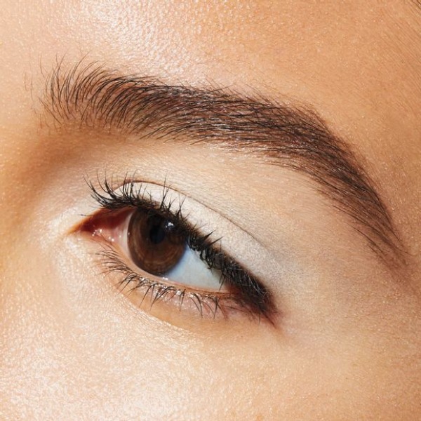 Close up of a woman's eye area as she looks off to the left and shows off her perfectly groomed eyebrows