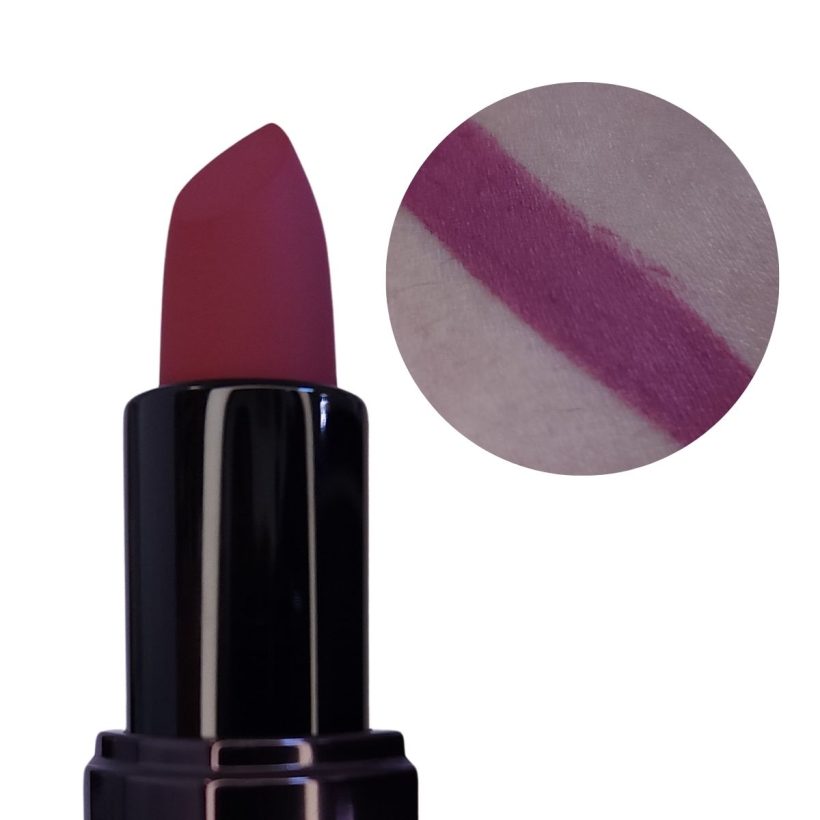 Open tube of vibrant purple lipstick with only the top half showing, next to a arm swatch of the same shade