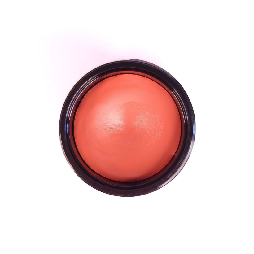 Open tub of Cashmere Multi-Balm in the shade Tropics, against a white background